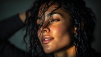 Young African American woman with wet hair and glowing skin in warm golden light, portrait photography for beauty and wellness campaigns.
