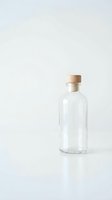 Empty clear glass bottle with wooden cork stopper on white background for packaging design and product mockups.