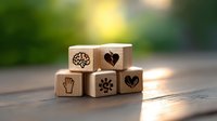 Wooden blocks with emotional intelligence and mental health symbols arranged on rustic table with soft bokeh background, wellness and psychology concept.