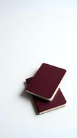 Stacked burgundy notebooks with cream-colored pages isolated on white background, suitable for stationery, education, and office design projects.