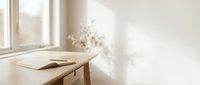 Minimalist wooden desk with open book near bright window in clean modern interior space with natural sunlight and soft shadows creating peaceful atmosphere.