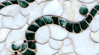 Elegant mosaic pattern with green malachite and white stone pieces creating a flowing serpentine design on marble background.