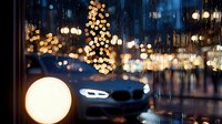 Blurred urban night scene with glowing bokeh lights and car silhouette creating atmospheric mood. Defocused golden orbs and raindrops on glass add dreamy effect.