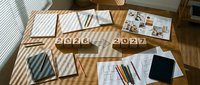Business planning workspace with 2026 and 2027 wooden number blocks, notebooks, documents and stationery on wooden desk for strategic goal setting.