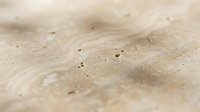 Close-up of fine sand texture with natural ripples and small holes created by wind patterns, showcasing desert or beach surface details for backgrounds.