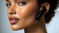 Young African American woman with flawless glowing skin wearing wireless earbuds, close-up beauty portrait showing natural makeup and glossy lips against light background.