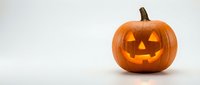 Carved Halloween pumpkin jack-o-lantern with glowing face isolated on white background for autumn holiday decorations and seasonal designs.