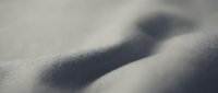 Close-up of smooth snow surface with shadow cast across white powder, suitable for winter backgrounds, seasonal designs, and cold weather concepts.