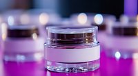Luxurious cosmetic cream jar on purple background with bokeh lights, closeup view of premium skincare product packaging for beauty industry marketing.