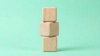 Stacked wooden blocks on mint background, isolated design element for branding, business concepts, stability metaphors, and creative projects.