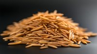 Pile of raw brown rice grains on dark background with selective focus and shallow depth of field, showing natural texture and organic food concept.