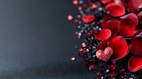Red rose petals scattered with dark granules on textured surface creating romantic Valentine's Day composition for greeting cards and love-themed designs.