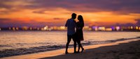 Romantic couple silhouette walking on beach at sunset with golden sky and ocean waves, perfect for love and relationship concepts in marketing materials.