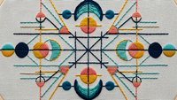 Geometric embroidery pattern with colorful circles, triangles and lines on fabric background for textile design and craft projects.