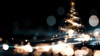 Magical glowing Christmas tree shape created by light trails and sparkles against dark background with festive bokeh lights for holiday designs.