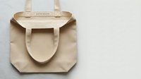 Blank natural canvas tote bag with handles isolated on white background, ready for custom printing, branding, and design projects.