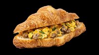 Croissant sandwich filled with scrambled eggs and sausage, isolated on transparent background, ready for menu design, restaurant graphics, food packaging, print-on-demand products, and culinary marketing materials.