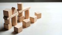 Wooden building blocks scattered on white surface creating abstract geometric composition for educational toys and creative play concepts.