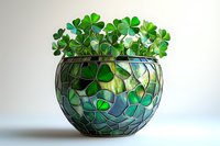 Fresh green shamrock plants growing in decorative mosaic glass bowl against light background, creating natural home decor arrangement for St Patrick's celebration.