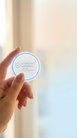 Woman's hand holding a round contract verified trusted documentation badge, symbolizing legal approval, certification, and secure business agreement.