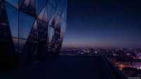 Modern glass building facade reflecting night cityscape with illuminated urban skyline, suitable for corporate, architecture, and real estate design projects.