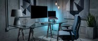 Gamer workspace with dual monitors, gaming chair, and neon blue lighting in modern industrial loft setting for tech and gaming content.