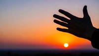 Hand silhouette reaching toward golden sunset sky, symbolizing hope, freedom and new beginnings. Inspirational concept for motivation and personal growth.
