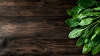 Fresh raw spinach leaves on dark wooden rustic background with copy space for text, top view. Natural organic food photography layout.