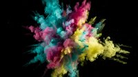 Vibrant multicolored powder explosion with cyan, magenta, and yellow dust clouds bursting against black background for creative design projects.