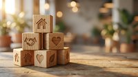 Wooden blocks with carved symbols including house, handshake, heart and leaf arranged on table representing home, community and environmental values.