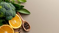Fresh broccoli and orange slices with peppercorns on neutral background, ideal for healthy eating, nutrition, and wellness content.