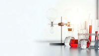 Laboratory glassware with red liquid samples on white table in modern research facility for scientific experiments and chemical analysis.