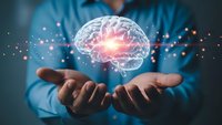 Businessman holding glowing brain with neural connections and light effects representing artificial intelligence, innovation and mental power concepts.