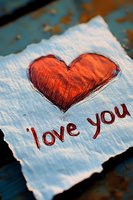 Hand-drawn red heart with love you message on textured paper for romantic greeting cards and Valentine's Day designs.