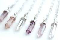 Crystal healing necklaces with amethyst and rose quartz gemstone pendants in silver settings for spiritual wellness and meditation practices.