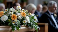 Elegant funeral flower arrangement with white daisies and orange chrysanthemums on wooden casket during memorial service ceremony.