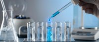 Laboratory scientist conducting chemical analysis with pipette and test tubes in modern research facility for pharmaceutical development.