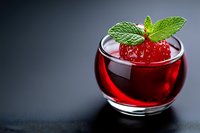 Fresh strawberry cocktail with mint garnish in elegant glass cup on dark background for beverage and drink concepts.