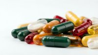 Colorful pharmaceutical capsules and pills scattered on white background for medical healthcare and treatment concepts.