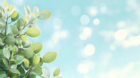 Fresh green leaves against soft turquoise bokeh background, spring foliage with sunlight and blurred circles creating dreamy natural atmosphere.