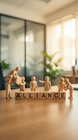 Wooden figurines arranged around letter blocks spelling alliance on office desk with natural light, representing business partnership, teamwork, and corporate collaboration.