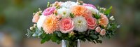 Wedding bouquet with pink roses, white chrysanthemums and orange dahlias wrapped in ribbon for bridal ceremony and romantic celebration events.