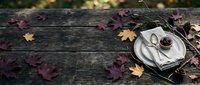 Autumn table setting with fallen leaves on rustic wooden background for seasonal dining and thanksgiving celebrations.