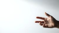 Hand reaching out with three fingers extended against clean white background for business presentations and communication concepts.