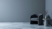 Modern minimalist living room interior with dark gray armchair and round side table against blue-gray wall for contemporary home design and decoration.