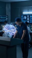 Male surgeon examining holographic brain projection in modern operating room with medical monitors and advanced technology equipment.