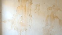 Old damaged wall with peeling paint and water stains showing weathered texture for renovation or restoration projects.