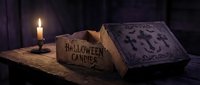 Antique Halloween spell book with burning candle creates mysterious gothic atmosphere for seasonal horror themes and occult storytelling projects.