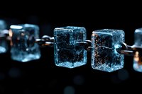 Glowing blue ice cubes connected by metal chain links on dark background create mysterious atmosphere, dramatic lighting highlights frozen water structure.