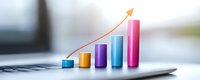 Colorful ascending bar graph with upward arrow showing growth trend on laptop keyboard, representing business success and positive financial performance.